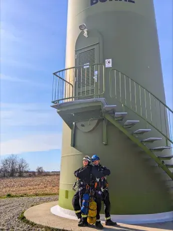 Un technicien et une technicienne éolien devant une éolienne Boralex au Canada